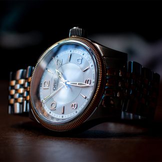 Metal traditional dress watch laying sideways.